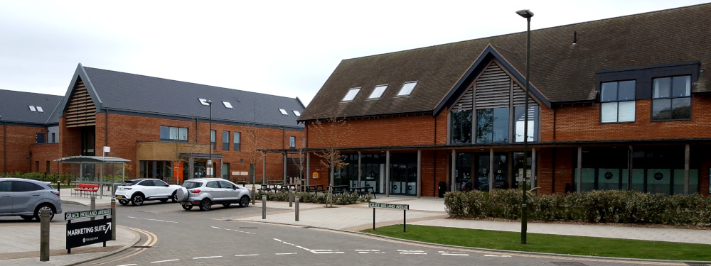 Modern two-storey brick buildings with a road and a small car parking area in front